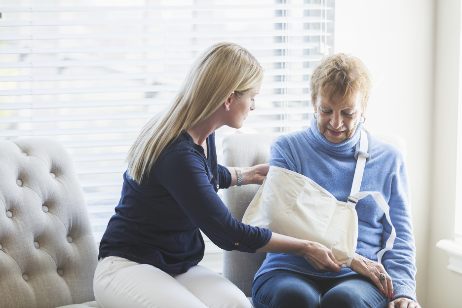 nurse helping woman with broken arm due to nursing home neglect