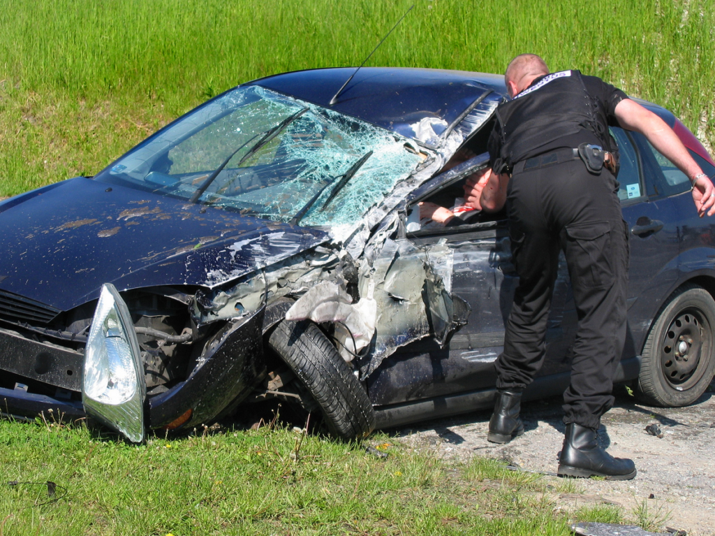 cop helping person out of car after auto collision