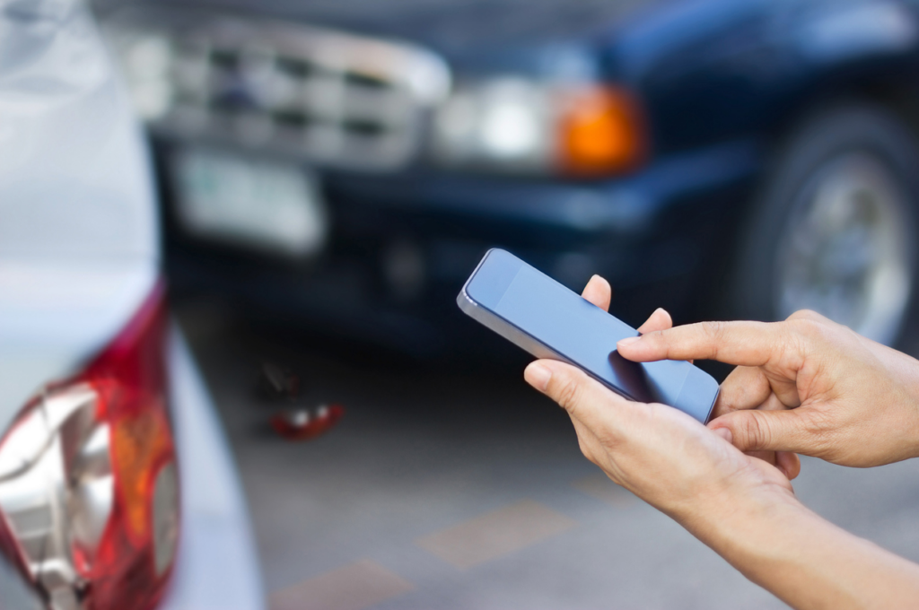 person-using-phone-to-post-about-auto-accident-on-social-media