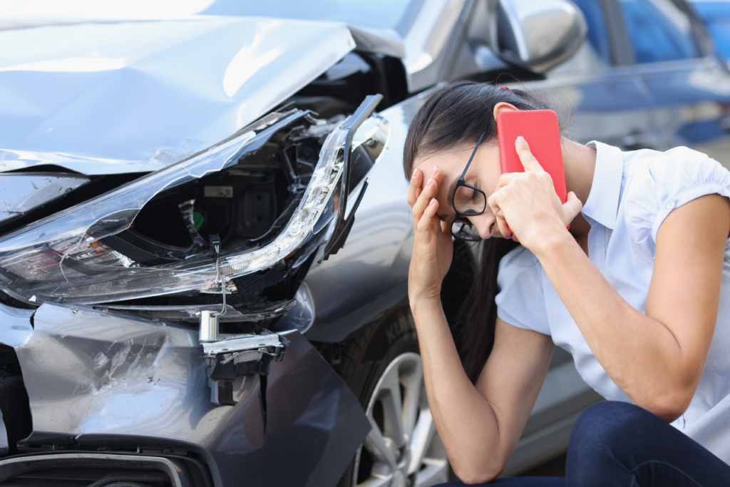 woman-on-cell-with-personal-injury-attorney-at-scene-of-car-accident
