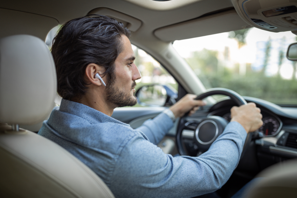 man-driving-while-wearing-ear-buds