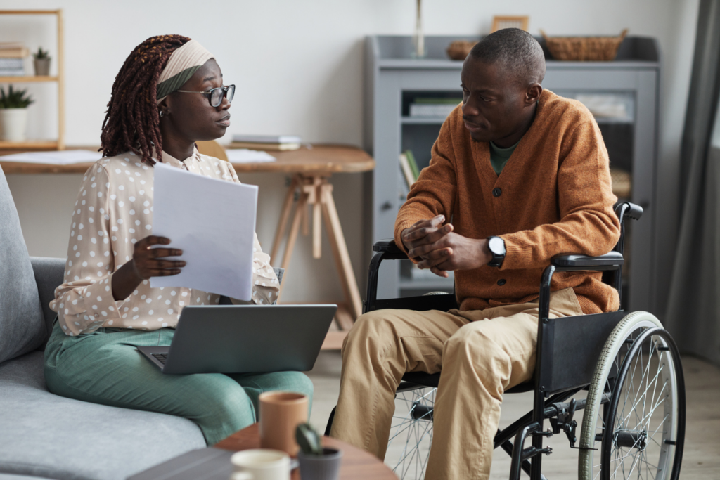 man in wheelchair working with lawyer to get damages for incapacitating injuries 