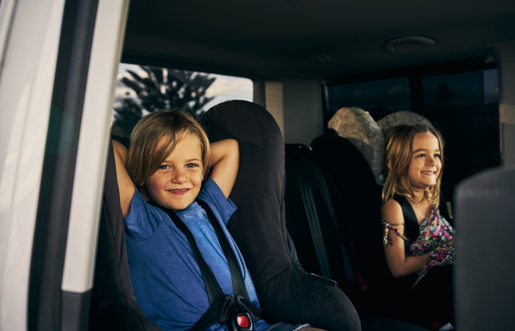 toddler boy and girl in car seats in back of car