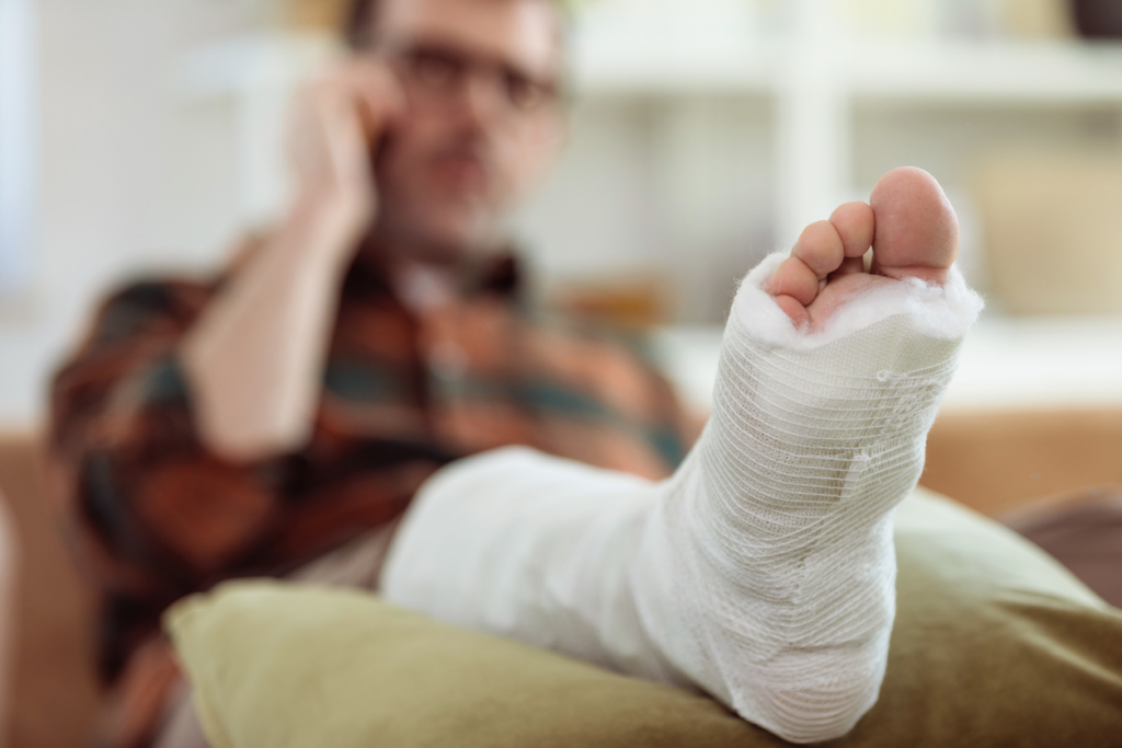 man-with-broken-foot-on-phone-with-personal-injury-attorney