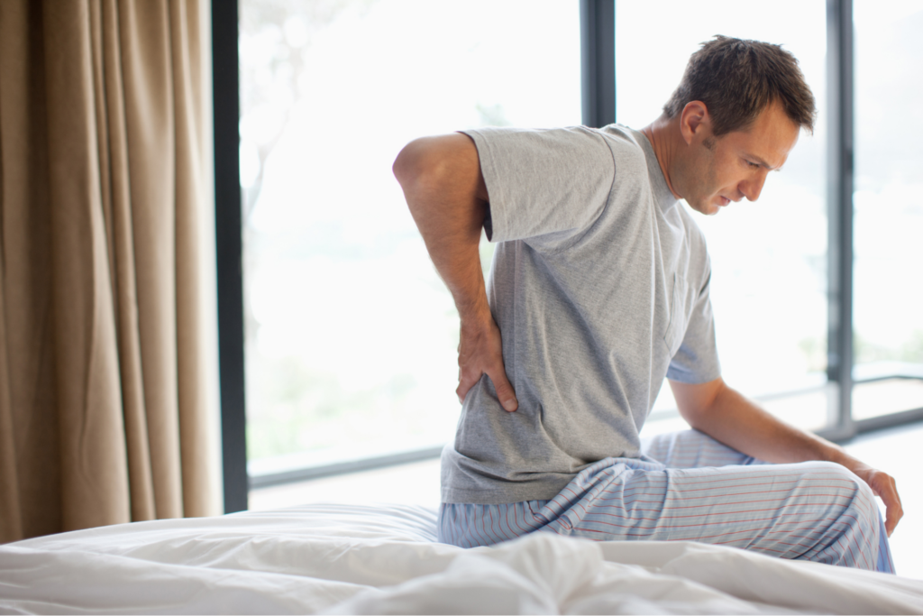 man-gettingp-out-of-bed-holding-back-after-car-accident