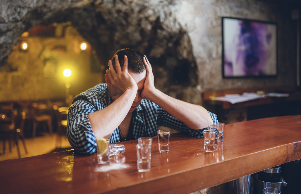 SC-man-holding-head-after-drinking-at-bar