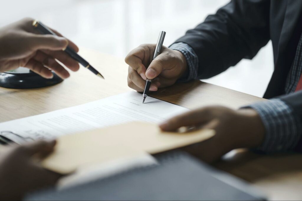 person-signing-paperwork-during-mediation