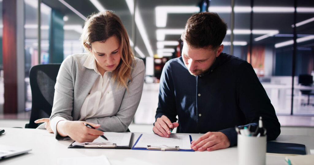 lawyer reviewing paperwork with client during mediatioon